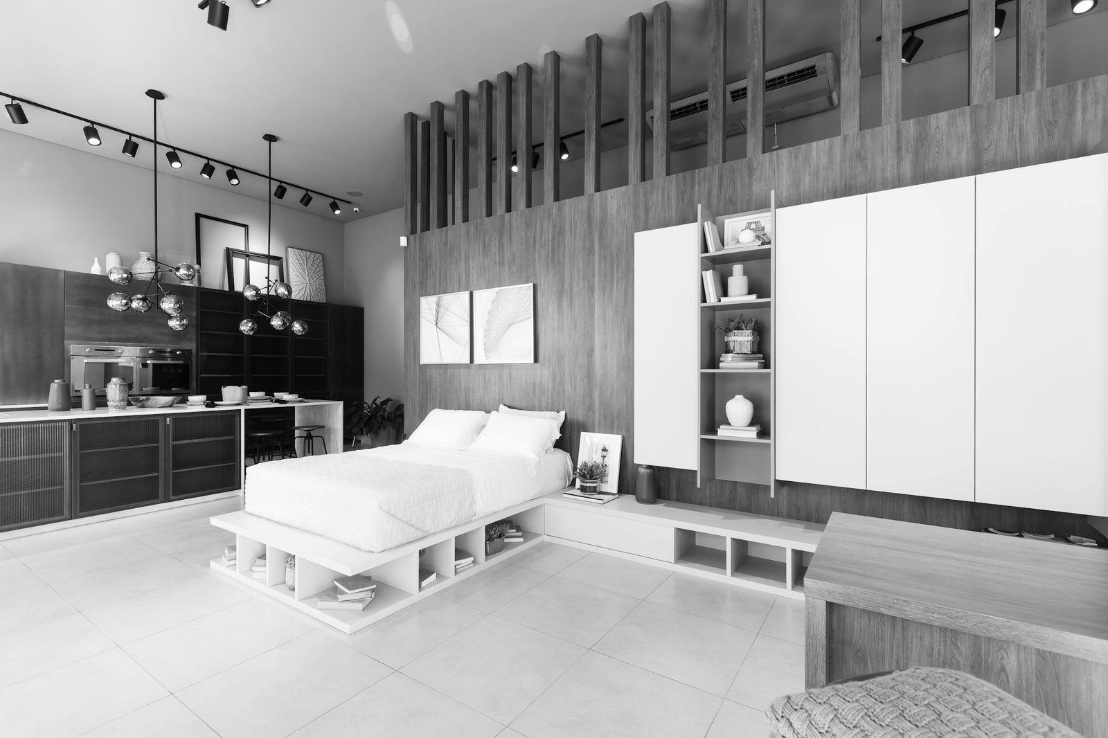 Black and white image of a modern minimalist bedroom with sleek furniture and lighting.